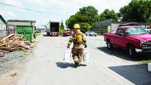 Photo by Brandon Hicks A firefighter carries supplies to the site of a hazardous material spill near downtown Elizabethton Friday.