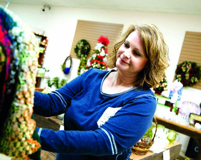 Star Photo/Bryce Phillips Cottage Boutique owner Sherri Horne works on a display of scarves.