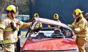 Star Photo/Rebekah Price  Firefighters remove the top of the car, which allows access to a victim.